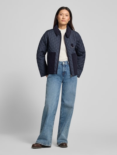 Modelka kobieca nosi Regular Fit Steppjacke mit aufgesetzten Seitentaschen Modell 'AYLESBY' od Barbour, granatowa, teksturowana, damska steppjacka, widok całej sylwetki z przodu.