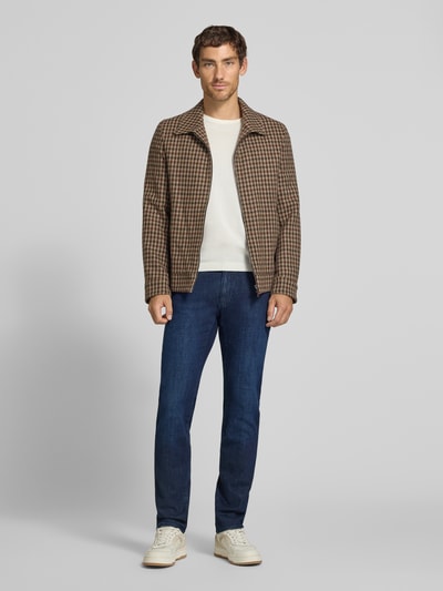 Männermodel trägt Modern Fit Jeans aus Baumwoll-Mix Modell 'Chuck' von Brax in Denim-Optik, 5-Pocket, Vorderansicht, Ganzkörperansicht von vorne.
