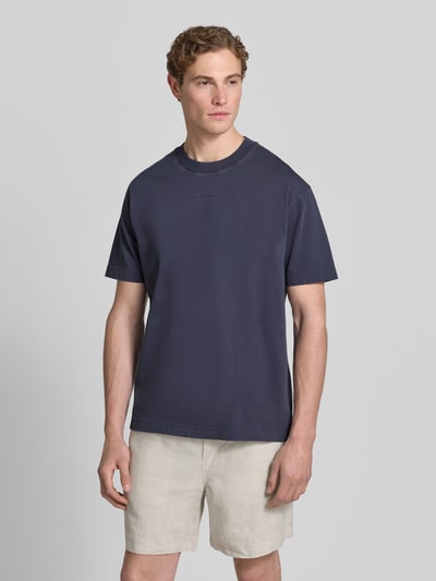 Männermodel trägt Relaxed Fit T-Shirt aus reiner Baumwolle von Marc O'Polo in Optik: Unifarben mit Label-Schriftzug, Ganzkörperansicht von vorne.