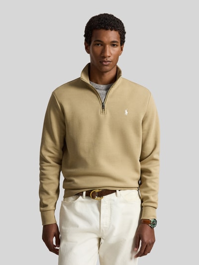 Männermodel trägt Relaxed Fit Troyer aus Baumwoll-Mix von Polo Ralph Lauren in Beige mit Reißverschluss, glatte Textur, Ganzkörperansicht von vorne. Herren Troyer von Polo Ralph Lauren.