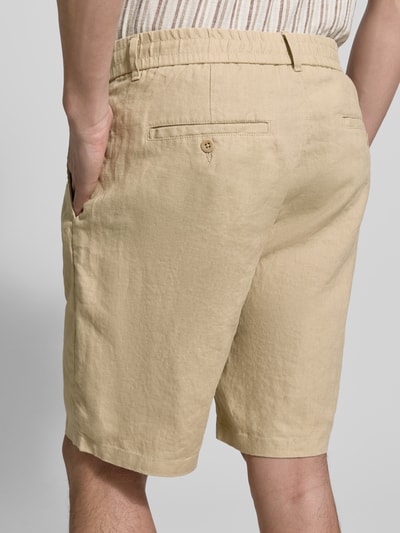 Männermodel trägt Shorts aus linnen met achterzakken van Gant, regular fit, elastische band, beige, detailaufnahme achterzijde.