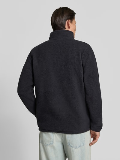 Männermodel trägt Fleecejacke mit Stehkragen Modell 'Jasper' von Columbia in Schwarz, weiche Struktur, Rückenansicht, Ganzkörperansicht Rückansicht. Herren Fleecejacke, gerade Passform, durchgehender Reißverschluss, Brusttasche mit Zipper, Label-Patch, seitliche Eingrifftaschen, elastische Ärmelabschlüsse, Rückenlänge 72 cm, Ärmellänge 71 cm, Schulterbreite 47 cm, Brustweite 46 cm.