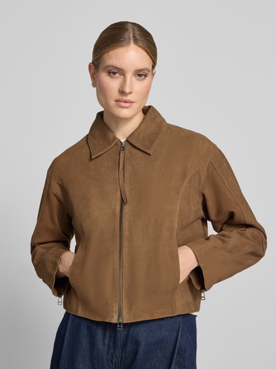 Frauenmodel trägt Lederjacke mit Zweiwege-Reißverschluss Modell 'SALERA' von YAS, braunes Ziegenleder, Umlegekragen, Regular Fit, Ganzkörperansicht von vorne.