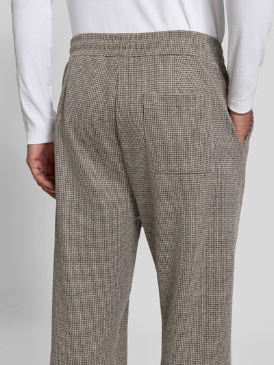 Männermodel trägt Straight Fit Stoffhose aus Baumwoll-Mix von DRYKORN, beige-grau, feine Struktur, Gesäßtasche, Nahaufnahme Rückansicht.