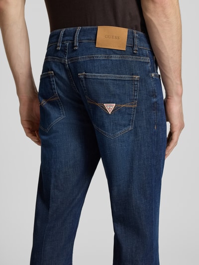 Männermodel trägt Slim Fit Jeans Modell 'ANGELS' von Guess in Dunkelblau, Baumwoll-Mix mit Stretch, Detailaufnahme Rückansicht.