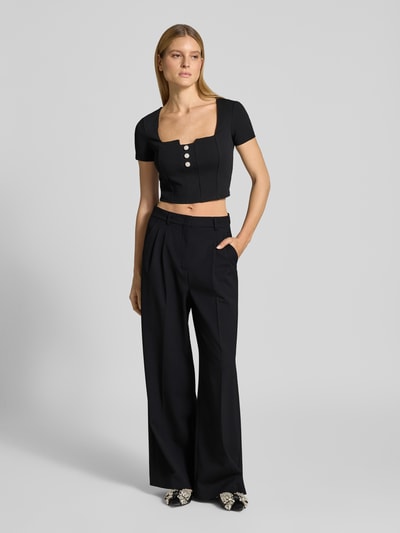 Vrouwenmodel draagt Cropped T-Shirt met Ziersteinbesatz Modell 'Evelina' van Guess, zwart, elastische materiaalmix, cropped fit, slim fit, voorkant hele lichaam.