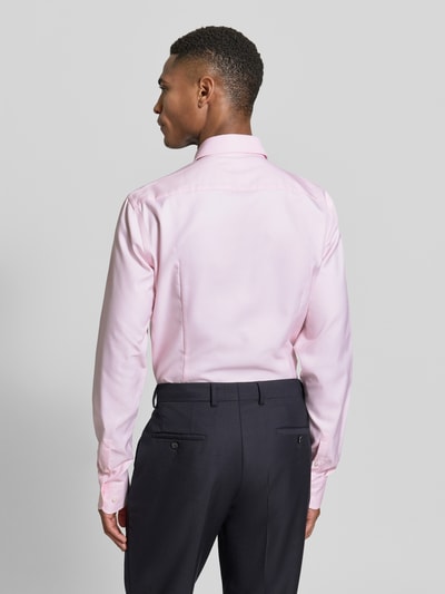 Männermodel trägt Slim Fit Businesshemd mit extra langem Arm Modell 'HANK' von BOSS, Optik: Unifarben, reine Baumwolle, Ganzkörperansicht Rückansicht.