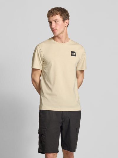 Mannelijk model draagt T-shirt uit katoenmix model 'EVOLUTION' van The North Face, regular fit, ronde hals, labelprint, voorkant volledige lichaamsopname.