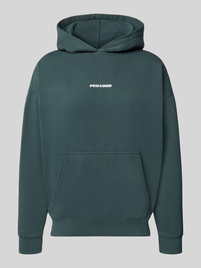 Produktfoto, zielona bluza z kapturem Oversized Fit Hoodie aus Baumwoll-Mix Modell 'CLARITA' von PEGADOR, mieszanka bawełny, krój oversized fit, detal z logo, kieszeń kangurka, elastyczne wykończenia