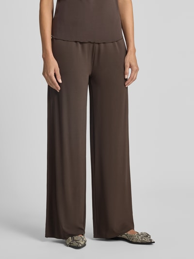 Vrouwenmodel draagt Straight Fit broek uit viscosemix Model 'Saumi' van Samsøe Samsøe, elastische band, bruine kleur, vooraanzicht volledige lichaam. Bandwijdte maat S: 37 cm, Binnenbeenlengte maat S: 84 cm.