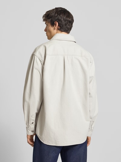 Männermodel trägt Regular Fit Hemdjacke mit Zweiwege-Reißverschluss von Carhartt Work In Progress aus reiner Baumwolle in Beige mit Kentkragen, Rückansicht Ganzkörperansicht.