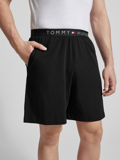 Männermodel trägt Regular Fit Sweatshorts aus Baumwoll-Mix von Tommy Hilfiger, schwarz, elastischer Bund mit Logo, Jersey Sweat, Nahaufnahme Oberkörper.