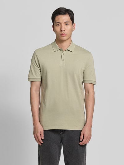 Männermodel trägt Regular Fit Poloshirt aus reiner Baumwolle Modell 'DONOS222' von HUGO in Beige mit Label-Applikation, Ganzkörperansicht von vorne.