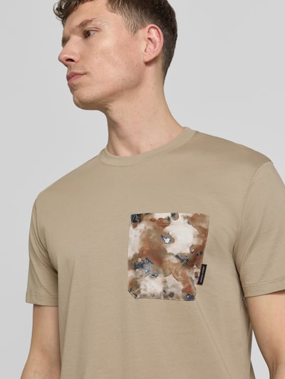 Männermodel trägt T-Shirt mit Brusttasche von ARMANI EXCHANGE in Beige, Reine Baumwolle, Gerader-Schnitt, Rundhalsausschnitt, Label-Detail, Nahaufnahme Oberkörper.