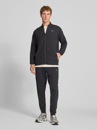 Männermodel trägt Sweatjacke mit Stehkragen und Reißverschluss Modell 'CLOUDSPUN' von PUMA PERFORMANCE, Material-Mix, Ganzkörperansicht von vorne.