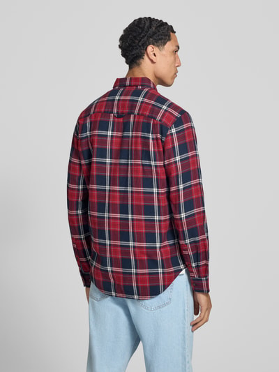 Männermodel trägt Regular Fit Freizeithemd aus reiner Baumwolle von Superdry in Rot-Blau-Karo, weiche Textur, Ganzkörperansicht Rückansicht. Rückenlänge bei Größe M 67 cm, Schulterbreite 44 cm, Ärmellänge 65 cm, Button-Down-Kragen, 1-Knopf-Manschetten.