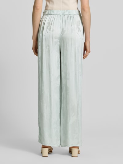 Frauenmodel trägt Weite Hose aus reiner Viskose von Calvin Klein Womenswear, Optik:Allover-Muster, Passform: Wide-Leg, Bundabschluss: elastisch, seitliche Eingrifftaschen, Materialverarbeitung: Jacquard, Material: reine Viskose, hellgrüne Farbtöne, fließende Oberfläche, Ganzkörperansicht Rückansicht.