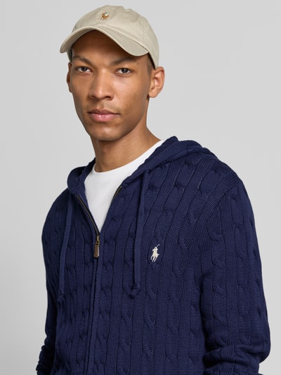 Mężczyzna nosi kardigan rozpinany Regular Fit Strickjacke aus reiner Baumwolle od Polo Ralph Lauren, granatowy splot, widok z przodu, zbliżenie na górną część ciała.