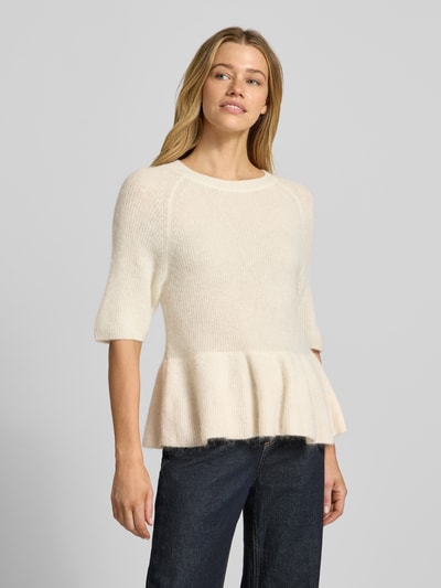 Frauenmodel trägt Strickpullover aus Alpaka-Mix Modell 'Thora' von MOS MOSH in Creme, weiche Textur, Rundhalsausschnitt, Regular Fit, Ganzkörperansicht von vorne. Damenpullover mit Baumwoll-Anteil und kurzen Ärmeln, Rückenlänge 54 cm, Ärmellänge 42 cm, dezente Struktur.