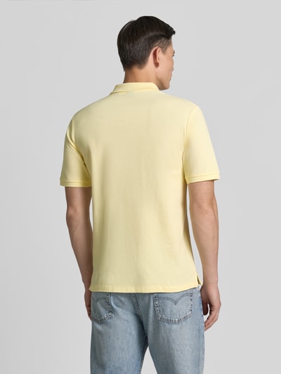 Męski model nosi Slim Fit Poloshirt mit Stitching von Jack & Jones Premium, żółta bawełna, haft, krój slim fit, listwa guzikowa, długość tyłu w rozmiarze M: 70 cm, całopostaciowy widok z tyłu.