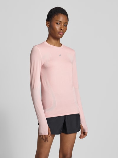 Frauenmodel trägt Slim Fit Longsleeve mit Logo-Print Modell 'Road' von ASICS TIGER in zartem Rosa, Rundhalsausschnitt, glatte Struktur, Ganzkörperansicht von vorne.