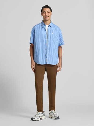 Męski model nosi chinosy Chino mit Eingrifftaschen Modell 'MARCO' od JACK & JONES, krój straight fit, brązowe, wpuszczane kieszenie, zapięcie na guzik i zamek błyskawiczny, Szerokość w rozmiarze 32/32: 42 cm, Długość wewnętrzna nogawki w rozmiarze 32/32: 77 cm, Ganzkörperansicht von vorne.