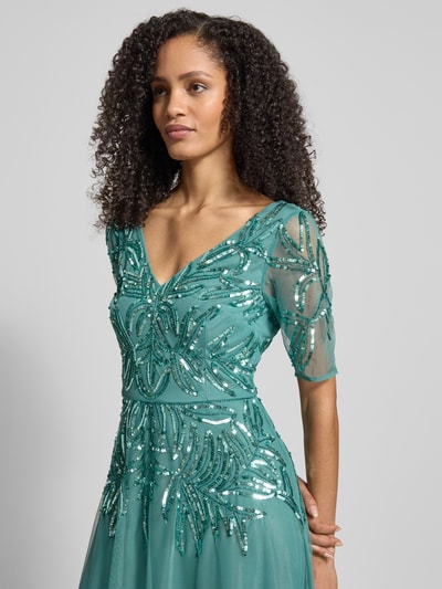 Frauenmodel trägt Abendkleid mit floralem Pailettenbesatz von Adrianna Papell in Türkis, V-Ausschnitt, Mesh, taillierte Passform, Nahaufnahme Oberkörper.