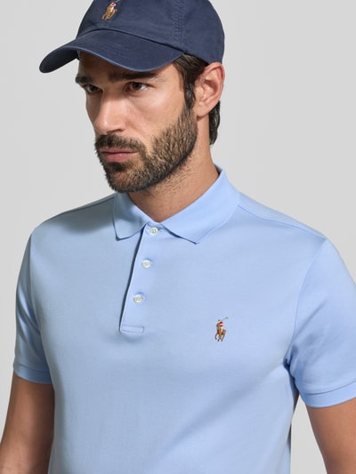 Männermodel trägt Poloshirt mit Label-Stitching van Polo Ralph Lauren in lichtblauw, katoenen regular fit, polokraag, nahaufnahme bovenlichaam.