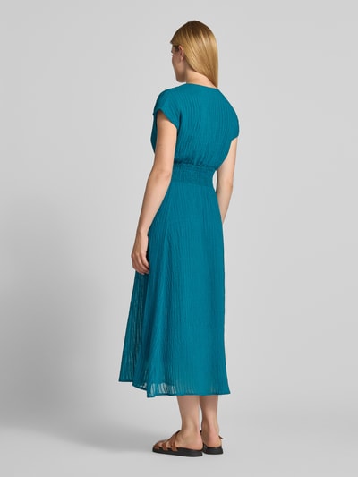 Frauenmodel trägt Midikleid aus Viskose-Mix mit Smok-Details von zero, türkisfarben, Strukturmuster, Ganzkörperansicht Rückansicht.