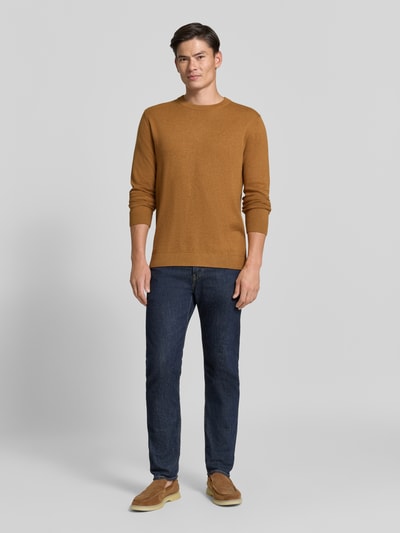 Männermodel trägt Regular Fit Pullover aus reiner Baumwolle von Tom Tailor in Braun zu Jeans, glatte Textur, Ganzkörperansicht von vorne. Herren Pullover von Tom Tailor.