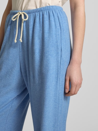 Frauenmodel trägt Sweatpants mit elastischem Bund Modell 'YPAWOOD' von American Vintage in Hellblau, Baumwoll-Mix mit Modal-Anteil, Loose Fit, Nahaufnahme Oberkörper.