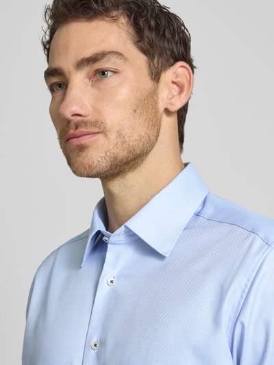 Męski model nosi Regular Fit Business-Hemd mit Kentkragen von ETERNA z czystej bawełny, listwa guzikowa, sportowe mankiety, niebieski, z długim rękawem, szerokość ramion 46 cm, długość tyłu 79 cm, długość rękawów 65 cm, zbliżenie na górną część ciała.