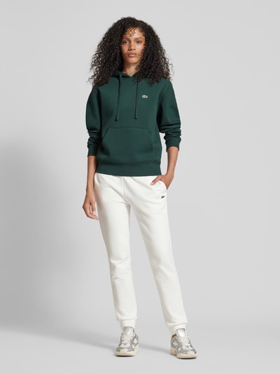 Lacoste Sport Spodnie dresowe o kroju relaxed fit z naszywką z logo Złamany biały 1