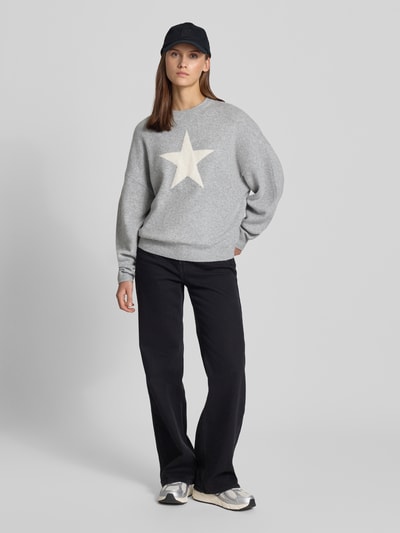 Vrouwenmodel draagt Regular Fit Pullover in tricotlook van review, materiaalmix met stretch, lange mouw, ribboorden, grijs met witte ster, volledig lichaam van voren.