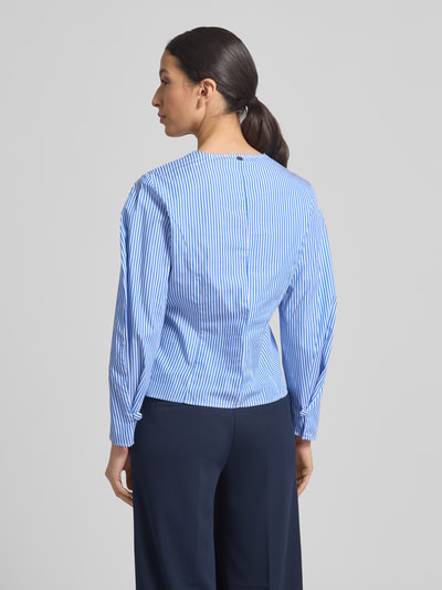 Frauenmodel trägt Bluse mit V-Ausschnitt und Knopfleiste von Rich & Royal in Hellblau mit weißen Streifen, reine Baumwolle, taillierter Schnitt, Ganzkörperansicht Rückansicht.