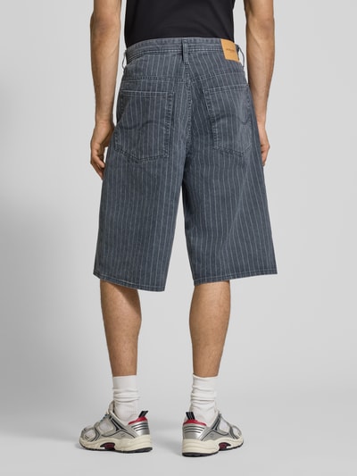 Männermodel trägt Shorts im Allover-Look Modell 'OWEN' von Jack & Jones, Reine Baumwolle, Relaxed-Fit, Eingrifftaschen, Ganzkörperansicht Rückansicht.