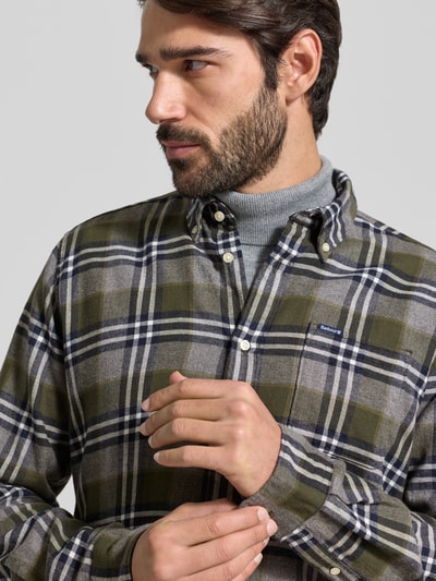 Männermodel trägt Slim Fit Freizeithemd aus reiner Baumwolle von Barbour in Gitterkaro, Button-Down-Kragen, Nahaufnahme Oberkörper.