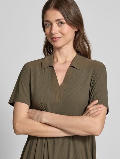 Frauenmodel trägt Midikleid mit Strukturmuster und Umlegekragen Modell 'JOSEPHINA' von Raffaello Rossi in Olivgrün, Nahaufnahme Oberkörper. Loose Fit, V-Ausschnitt, Material-Mix mit Stretch-Anteil.