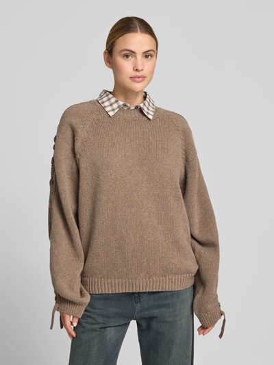 Frauenmodel trägt Oversized Sweatshirt aus Woll-Mix von ROTATE in Strick-Optik mit Flecht-Detail, Rundhalsausschnitt, braun, Ganzkörperansicht von vorne. Rückenlänge bei Größe S: 65 cm.