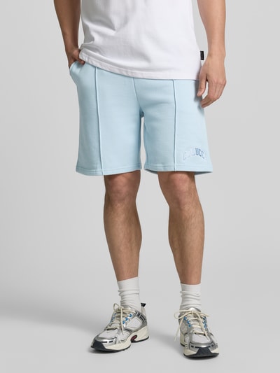 Männermodel trägt Regular Fit Shorts mit Tunnelzug von COLUCCI aus Reiner Baumwolle gewachst, hellblau mit Label-Stitching, Nahaufnahme Unterkörper.
