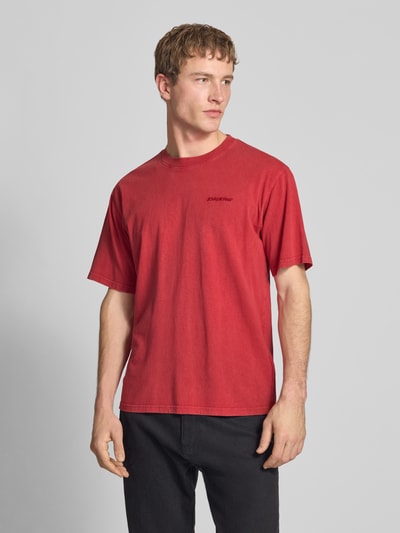 Männermodel trägt T-Shirt mit Rundhalsausschnitt und Label-Stitching van Dickies in rood, regular fit, pure katoen, vooraanzicht, bovenlichaam dichtbij.