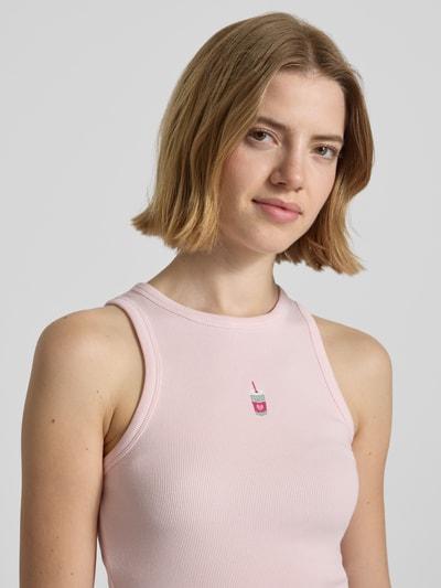 Frauenmodel trägt Tanktop mit Rundhalsausschnitt von REVIEW in Rosa, Baumwoll-Elasthan-Mix, Feinripp, eng anliegende Passform, Nahaufnahme Oberkörper.