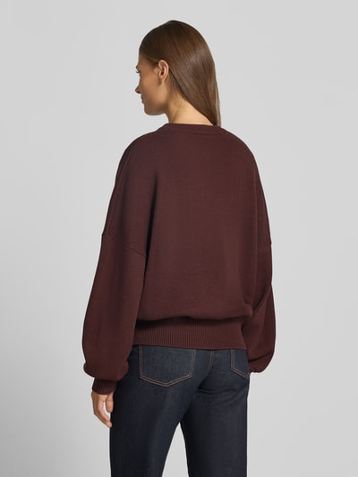 Frauenmodel trägt Oversized Strickpullover aus Viskose-Mix von aim'n in Dunkelbraun, Rundhalsausschnitt, Rückenlänge 59 cm, Ganzkörperansicht Rückansicht.