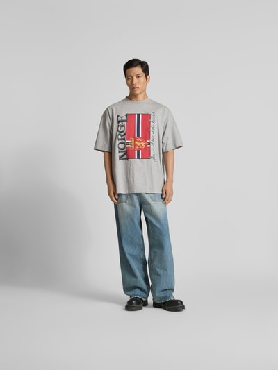 Männermodel trägt Herren T-Shirt mit Rundhalsausschnitt von VETEMENTS aus reiner Baumwolle, Lockerer-Schnitt, Unifarbenes-Design, Rückenlänge 79 cm, Ganzkörperansicht von vorne.