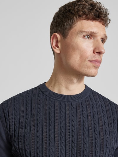 Mężczyznamodel nosi T-shirt mit Zopfmuster von Lindbergh z bawełny, prosty krój, imitacja dzianiny, okrągły dekolt, ścieg warkoczowy, długość tyłu w rozmiarze M: 68 cm, zbliżenie na górną część ciała