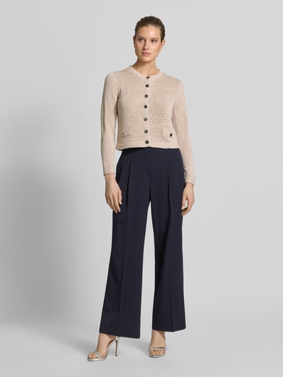 Frauenmodel trägt Strickjacke mit Rundhalsausschnitt und Knopfleiste von Betty Barclay, beige, Ziertaschen, Regular Fit, Ganzkörperansicht von vorne.