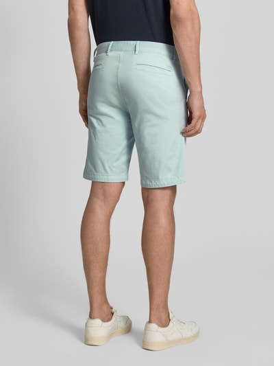 Männermodel trägt Slim Fit Chinoshorts aus Baumwoll-mix von BOSS Orange, unifarben, Label-Applikation, Ganzkörperansicht Rückansicht.