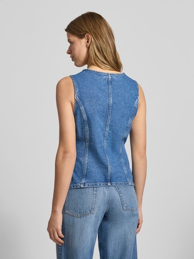 Frauenmodel trägt Jeansweste aus reiner Baumwolle Modell 'GUILINA' von ONLY in blauer Denim-Optik mit Paspeltaschen, Ganzkörperansicht Rückansicht.