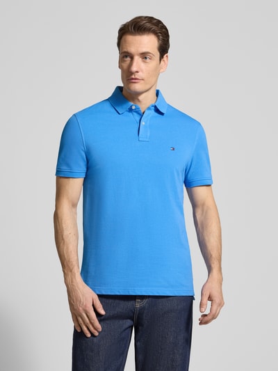 Männermodel trägt Regular Fit Poloshirt aus Baumwoll-Mix von Tommy Hilfiger, Optik: Unifarben, Logo-Stitching, Ganzkörperansicht von vorne.