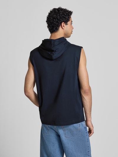 Männermodel trägt Hoodie mit Label-Stitching von CHAMPION aus Reine Baumwolle, Regular-Fit, Kapuze mit Tunnelzug, Rückenlänge 75 cm, Ganzkörperansicht Rückansicht.